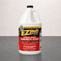Bottle of EZ Stain concrete stain on a gray surface with a light pink background