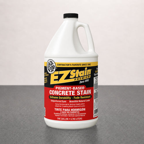 Bottle of EZ Stain concrete stain on a gray surface with a light pink background